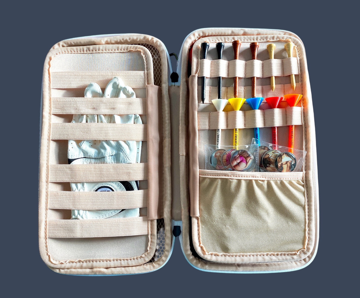 Open beige case with compartments containing various items on a dark background